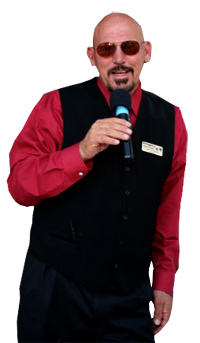 An mc in a red dress shirt, black vest and sunglasses posing with a mic.